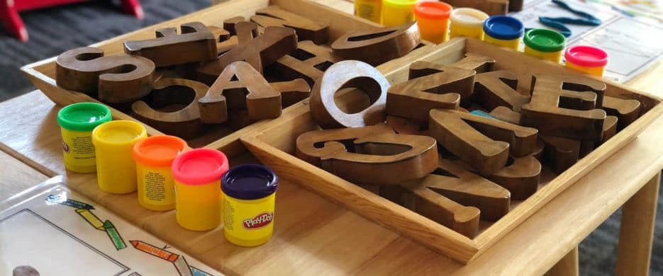 A table with large bock letters and play-doh